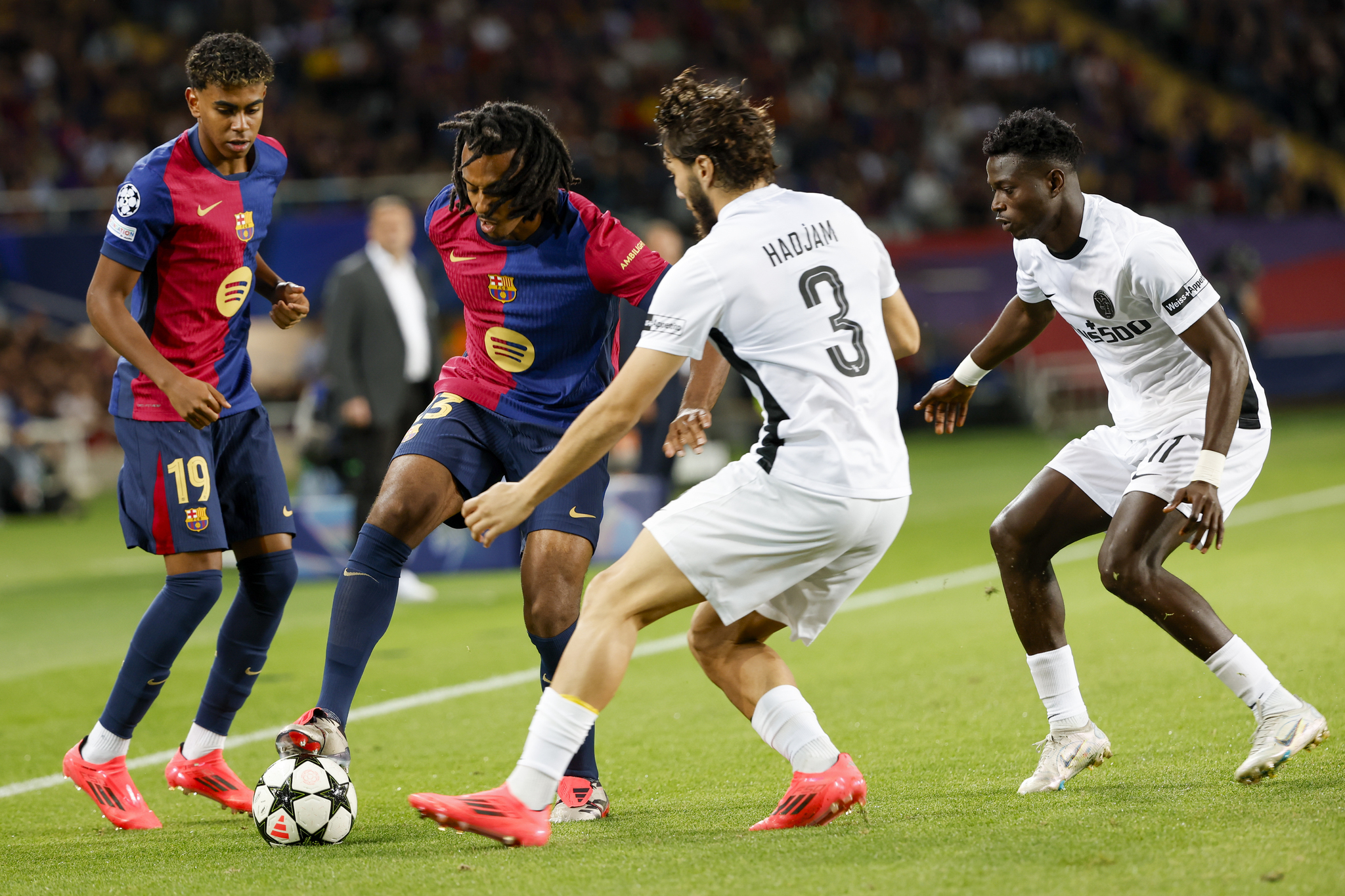 Jules Kounde, centre left, is challenged by Young Boys' Jaouen Hadjam during the Champions League soccer match between  lt;HIT gt;Barcelona lt;/HIT gt; and Young Boys at the Lluis Companys Olympic Stadium in  lt;HIT gt;Barcelona lt;/HIT gt;, Spain, Tuesday, Oct. 1, 2024. (AP Photo/Joan Monfort)