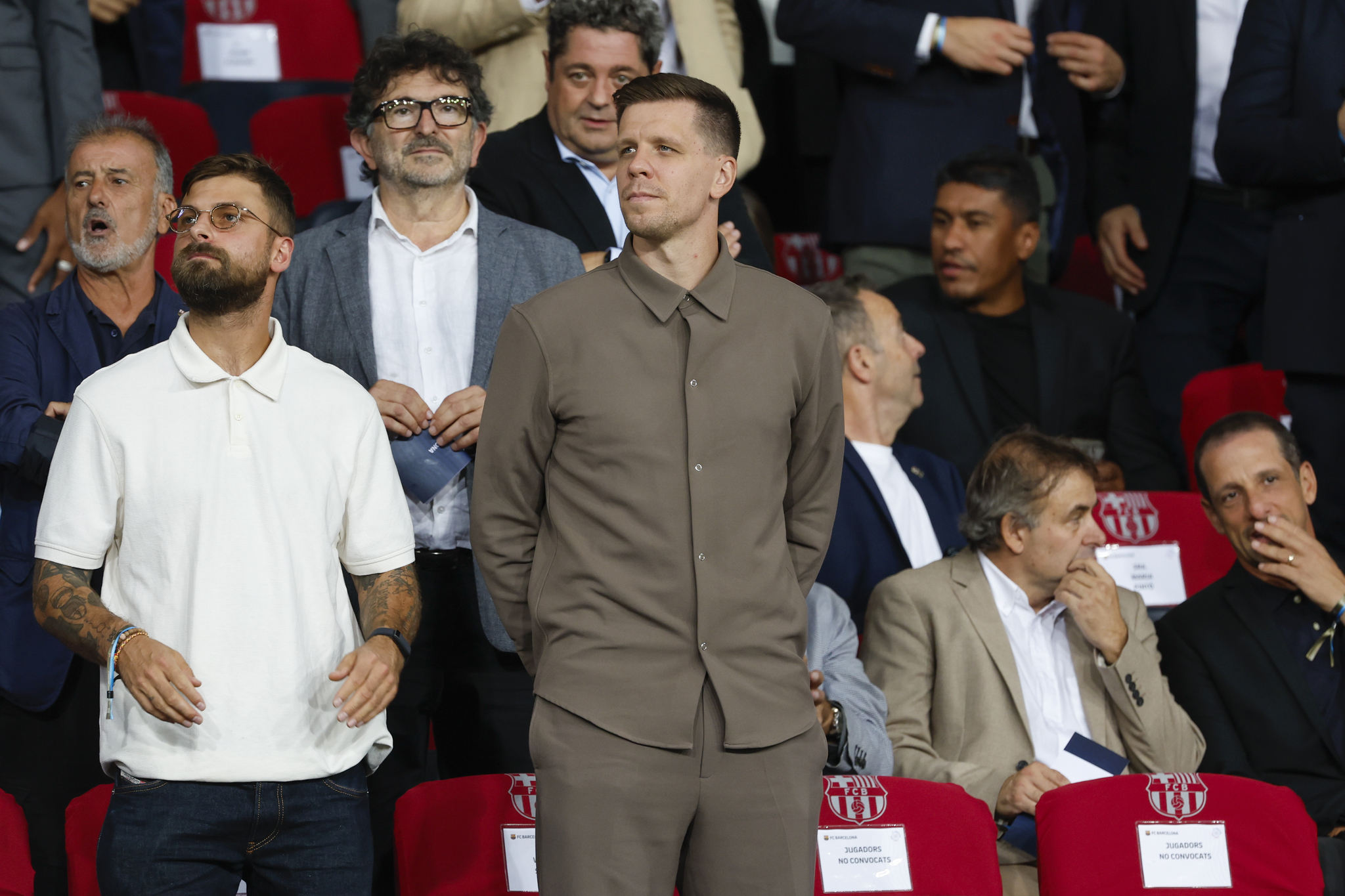 Wojciech Szczesny, centre, a new goalkeeper for  lt;HIT gt;Barcelona lt;/HIT gt; is on stands during the Champions League soccer match between  lt;HIT gt;Barcelona lt;/HIT gt; and Young Boys at the Lluis Companys Olympic Stadium in  lt;HIT gt;Barcelona lt;/HIT gt;, Spain, Tuesday, Oct. 1, 2024. (AP Photo/Joan Monfort)