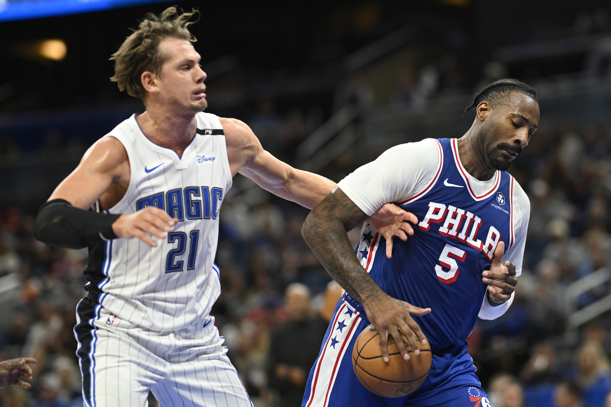 Philadelphia 76ers center Andre Drummond (5) gains control of a rebound in front of Orlando Magic center Moritz Wagner (21) during the first half of a preseason NBA basketball game, Friday, Oct. 18, 2024, in Orlando, Fla.