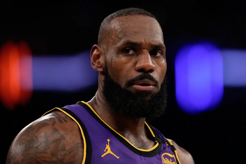 LeBron James brushes off a fan who appeared to be mocking him while Carmelo Anthony soaks in the moment