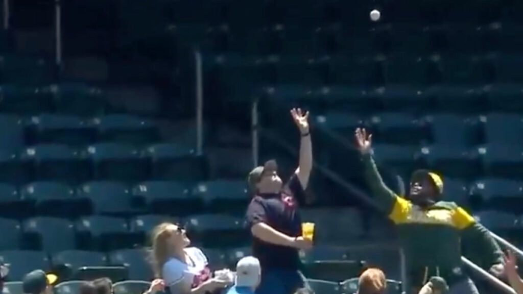 A Cleveland Guardians fan fails to catch the ball and ends up spilling beer on a woman causing a mess